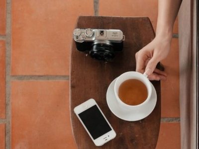 Camera, phone, and coffee on a side table