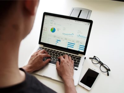 Man looking on graphs in laptop screen