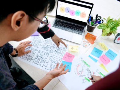 person working while holding a sticky notes